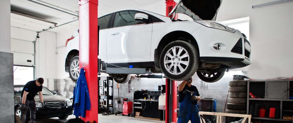 A room view of an auto shop with mechanics working