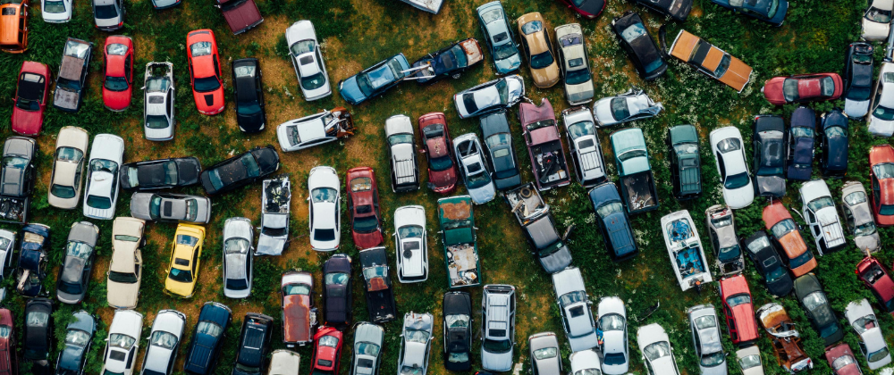 a top view of a car scrap yard with many vehicles parked